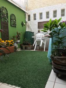 um pátio com piso verde, uma mesa e plantas em SOL Y SALSA bnb em Cuernavaca