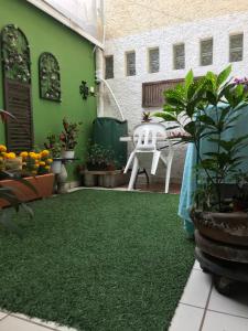 une terrasse avec un sol vert, une table et des plantes dans l'établissement SOL Y SALSA bnb, à Cuernavaca