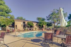 a pool with chairs and a table and an umbrella at The Painted Pony Condo with Pool and Gym Access! in Sedona