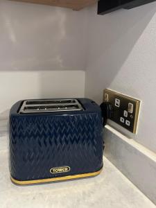 a blue suitcase sitting on a counter next to an outlet at 2 Bed Cottage, Houghton on the Hill, Leicestershire in Houghton on the Hill +36 photos