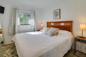 Un dormitorio con una gran cama blanca y una ventana en Higgins Lake Cottage with Private Fire Pit and Grill!, en Roscommon