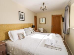 a bedroom with a large white bed with towels on it at Cross Cottage in Durham