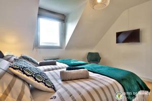 1 Schlafzimmer mit 2 Betten und einem TV an der Wand in der Unterkunft La Rose des Vents in Carantec