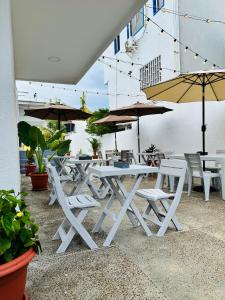 a group of white tables and chairs with umbrellas at AMBAR CASA BOUTIQUE in San Andrés