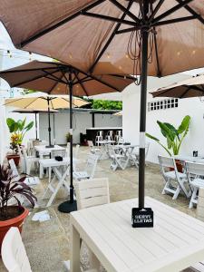 a patio with tables and chairs and umbrellas at AMBAR CASA BOUTIQUE in San Andrés