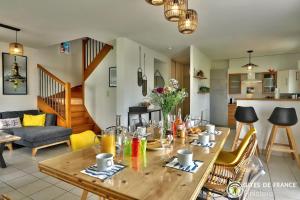 cocina y sala de estar con mesa de madera en La Rose des Vents, en Carantec