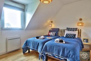 Dos camas con gatos en un dormitorio en La Rose des Vents, en Carantec