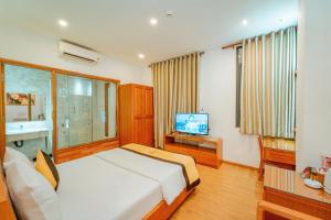 een slaapkamer met een bed en een televisie. bij Khách Sạn Cường Thanh 2 in Ho Chi Minh-stad
