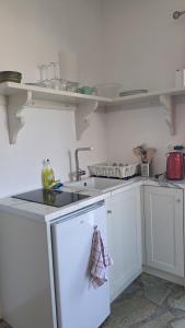 a kitchen with white cabinets and a sink at Spice Suites-Rosemary in Amorgos