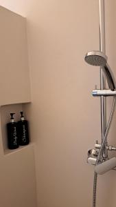 a shower in a bathroom with two black bottles at Spice Suites-Rosemary in Amorgos