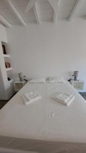 a white bed with two white pillows on it at Spice Suites-Rosemary in Amorgos