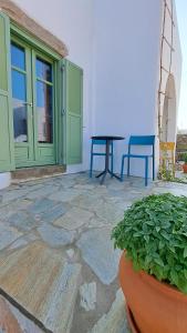 a patio with a table and chairs and a plant at Spice Suites-Rosemary in Amorgos