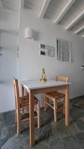 a dining room table with two chairs and a table and a table at Spice Suites-Rosemary in Amorgos