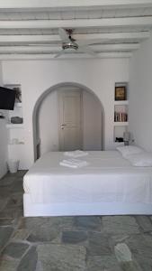 a white bedroom with a white bed and a ceiling at Spice Suites-Rosemary in Amorgos