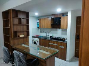 a kitchen with wooden cabinets and a counter top at Luxurious Apartment with a pool and gym near Trivandrum railway station in Trivandrum