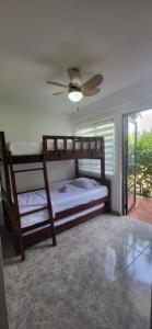 a bedroom with two bunk beds and a ceiling fan at Santa Marta La Magia De Tenerlo Todo in Santa Marta