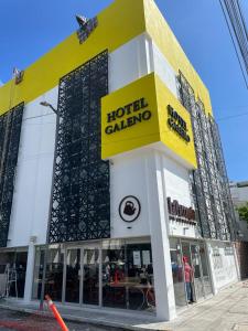 um edifício calzone de hotel com um sinal amarelo em Hotel GALENO em Veracruz