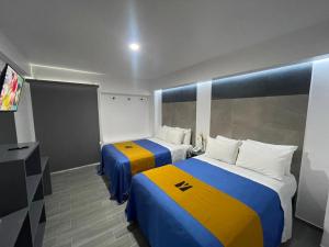 a hotel room with two beds and a tv at Hotel GALENO in Veracruz