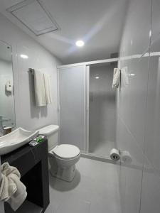 y baño con ducha, aseo y lavamanos. en Hotel GALENO en Veracruz