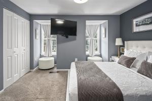 a bedroom with a large bed and a flat screen tv at Charming 3 bdr Thome, Suburban Nhbrhd, Near DC in Sterling