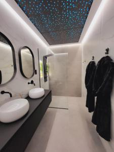 a bathroom with two sinks and two mirrors at suites home ruidera in Ruidera