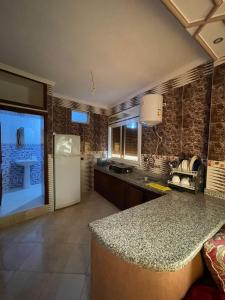 a kitchen with a counter top and a refrigerator at Appartement el hichou 1 in Ksar es Sghir