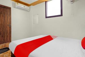 a red and white bed in a room with a window at Super OYO Flagship 81158 Hotel Aditya Inn in Patna
