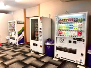 two refrigerators in a room with a soda machine at HOTEL THE NEXT KANKU in Sennan