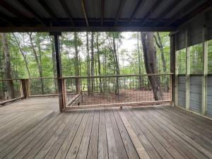 a screened porch with a view of the woods at The Happy Place In The Trees in Lake Murray Shores