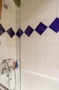 a shower in a bathroom with blue and white tiles at ANGEL - Pleasant 1Bdr Apartment in London
