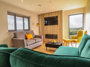 a living room with a couch and a chair at Mynydd Y Glyn Lodge in Llanfyllin