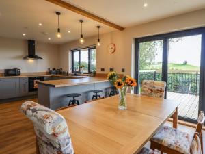 uma cozinha e sala de jantar com uma mesa de madeira e cadeiras em Mynydd Y Glyn Lodge em Llanfyllin
