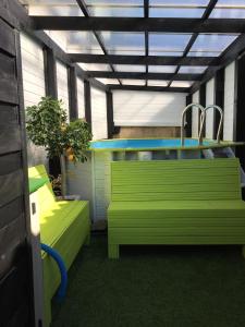 IsselにあるLe Domaine de Charline de 1 à 35 personnesの緑のベンチとシンクが備わる客室です。