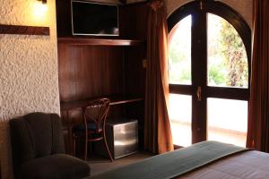 1 dormitorio con cama, ventana y silla en Hotel La Casa de Tin tin, en Arequipa
