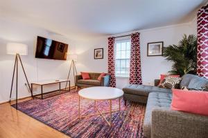 een woonkamer met een bank en een tafel bij Spacious 3-story Townhome 40 Minutes from DC Pet-Friendly, Fast WiFi, Perfect in Sterling