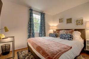 een slaapkamer met een bed met blauwe gordijnen en een raam bij Spacious 3-story Townhome 40 Minutes from DC Pet-Friendly, Fast WiFi, Perfect in Sterling