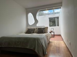 Schlafzimmer mit einem großen Bett und einem Fenster in der Unterkunft Casa Niza in Bogotá