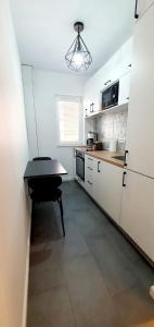 a kitchen with a black table and a refrigerator at D&C Studio II/Self-Check-In in Bucharest