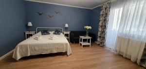 a blue bedroom with a bed and a chair at D&C Studio II/Self-Check-In in Bucharest
