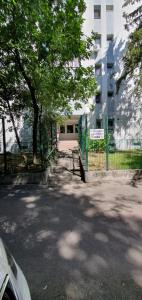 a fence with a tree in front of a building at D&C Studio II/Self-Check-In in Bucharest