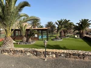 a building with palm trees and a street light at Hotel Rural Restaurante Mahoh in Villaverde