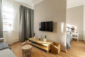 a living room with a couch and a tv on a wall at Apartmány KRAKENS in Šumperk