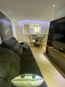 uma sala de estar com um sofá e uma televisão em Carlo’s house em Curitiba