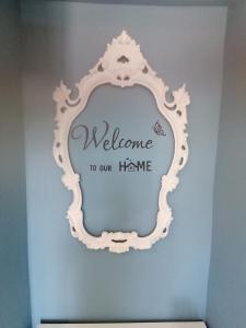 een spiegel in een kamer met een welkom in ons huis bij La casa di Trilly in Sanremo
