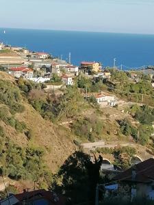 a view of a hill with houses and the ocean at La casa di Trilly in Sanremo