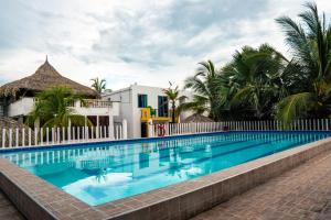 una piscina con una valla blanca y palmeras en Caribbean Town Tolu, en Tolú