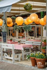 a restaurant with orange lanterns and tables and potted plants at Apartament Elegance - Pobierowo Baltic Apartments in Pobierowo