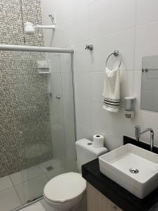 a bathroom with a toilet and a shower and a sink at Férias na Bahia in Porto Seguro