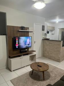 a living room with a tv and a coffee table at Férias na Bahia in Porto Seguro