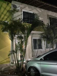 a car parked in front of a house with palm trees at Férias na Bahia in Porto Seguro